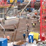 A bustling construction site in Hamburg with workers and equipment actively engaged in building tasks.