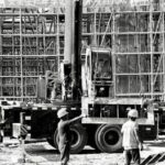 Black and white image showing construction workers and equipment on a busy building site in Shanghai.
