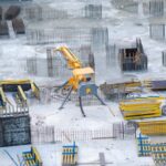 Aerial view of an active construction site with heavy machinery and building materials.